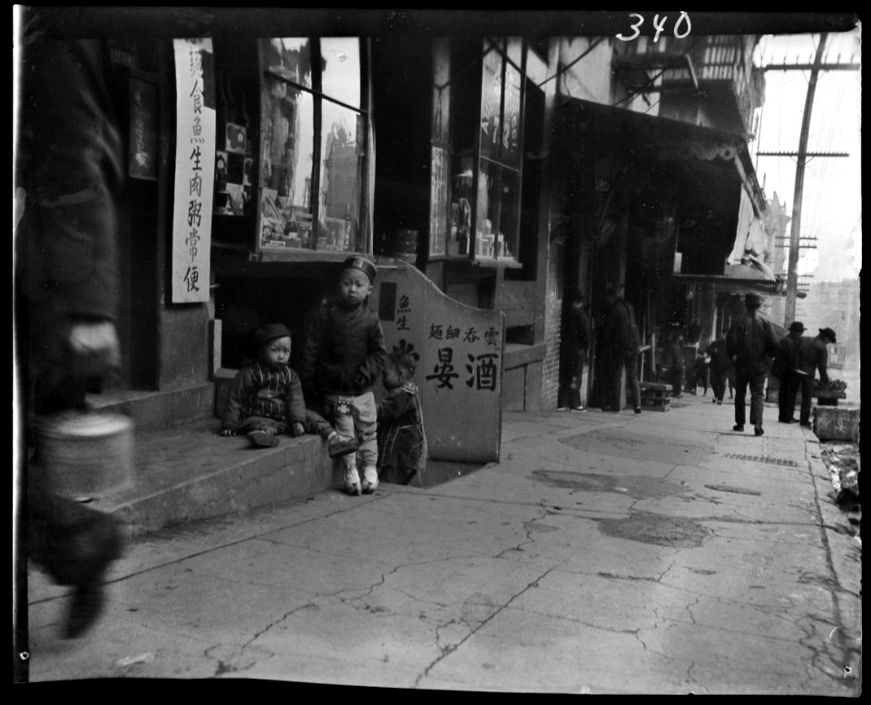 Three children in front of a cellar door, Chinatown, San Francisco LOC agc.7a09052