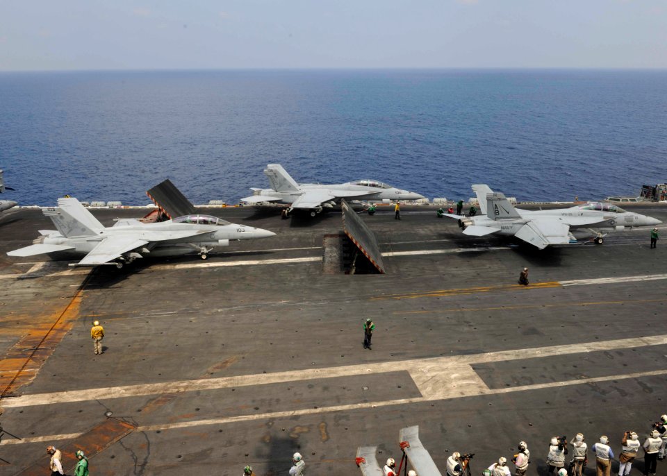 Three FA-18F Super Hornets prepare to take off from the flight deck of the USS Theodore Roosevelt