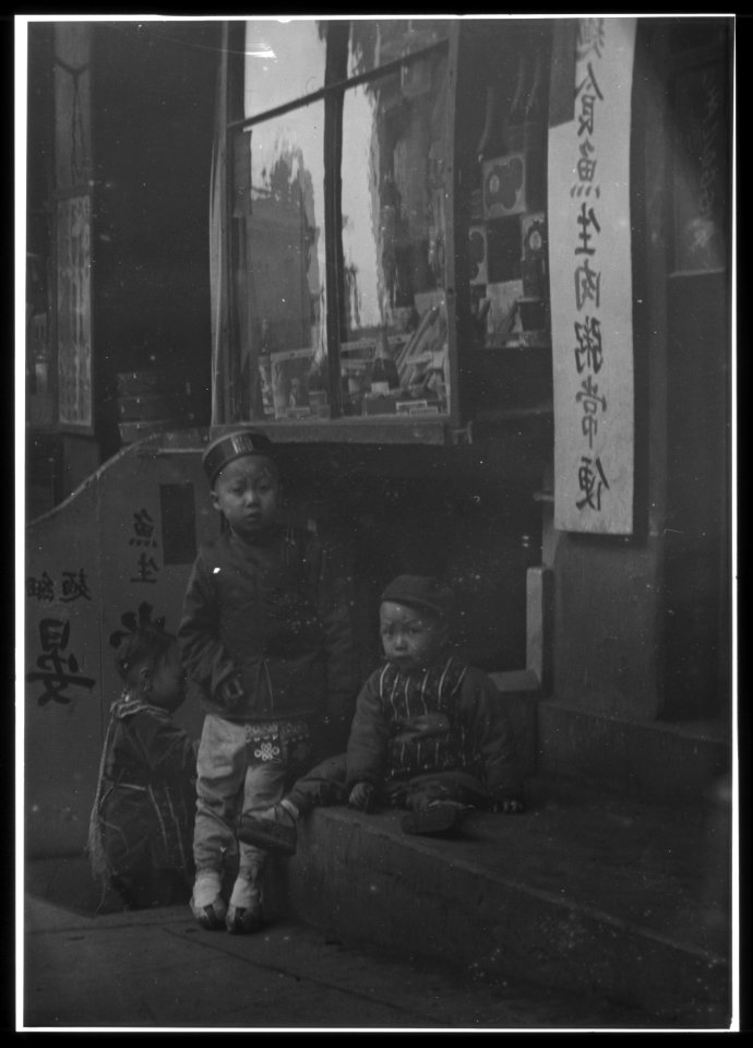 Three children in front of a cellar door, Chinatown, San Francisco LOC agc.7a55083