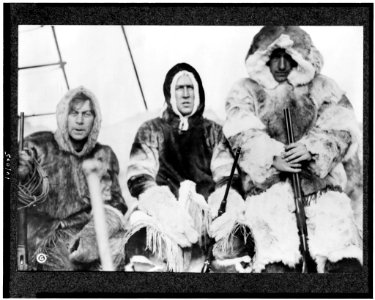 Three men in fur parkas holding guns on ship during Arctic expedition LCCN90709442