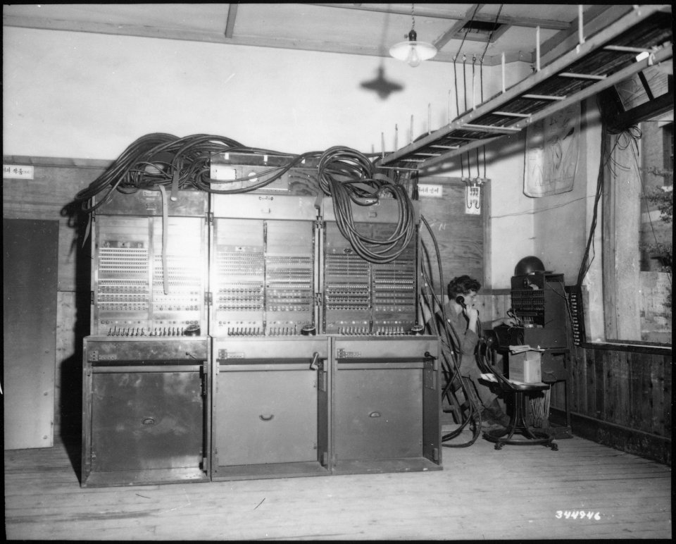 Three BD-110A switchboards on left and one BD-96 on extreme right being operated by Private First Class James Grahn... - NARA - 531366