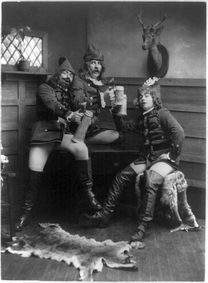 Three men in German student uniforms lifting beer steins LCCN2011660034