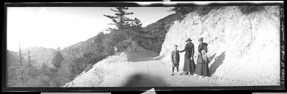 Three people on mountainside road cut, possibly Sierras near Yosemite LCCN2017656459