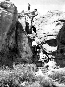 Three men climbing the foot trail to the top of the mesa of the Hopi (Moki) pueblo of Mishongnovi (Mashongnave), Arizona, ca.1898 (CHS-4604)