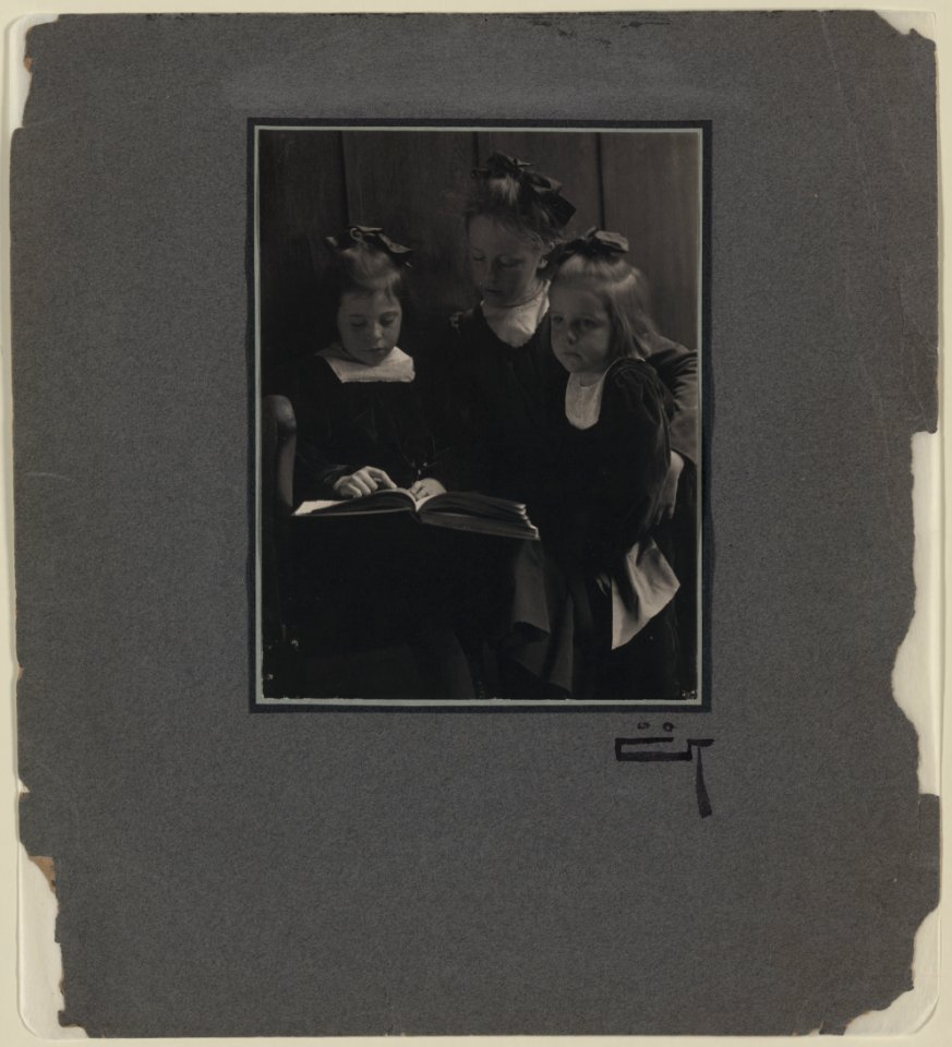 Three young girls reading a book LCCN2004676293