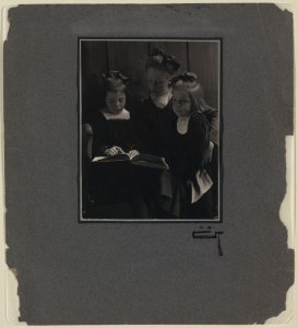 Three young girls reading a book LCCN2004676293