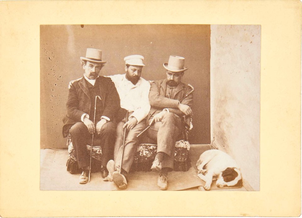 Three seated men and a sleeping dog