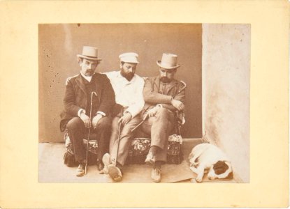 Three seated men and a sleeping dog