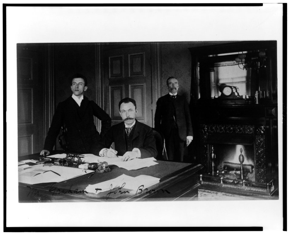 Three Treasury Department employees, Mr. Graham, John Brown, and another man, posed in an office with a fireplace LCCN00649582