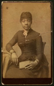 Three-quarter-length portrait of an African-American woman seated, facing front, holding book) - Edwards' Excelsior Photo. Gallery, 804 Main Street, Lynchburg, Va LCCN2010647841