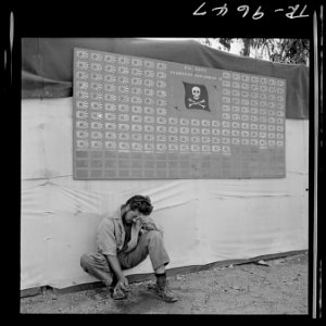 Tired member of VF-17 pauses under squadron scoreboard at Bougainville. - NARA - 520962