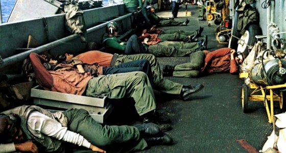 Tired flight deck personnel aboard USS Coral Sea (CVA-43), circa in 1972