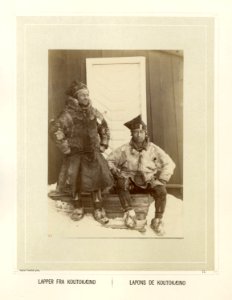 To samer i pesk og skaller sitter på trapp foran bygning - Norsk folkemuseum - NF.15006-076