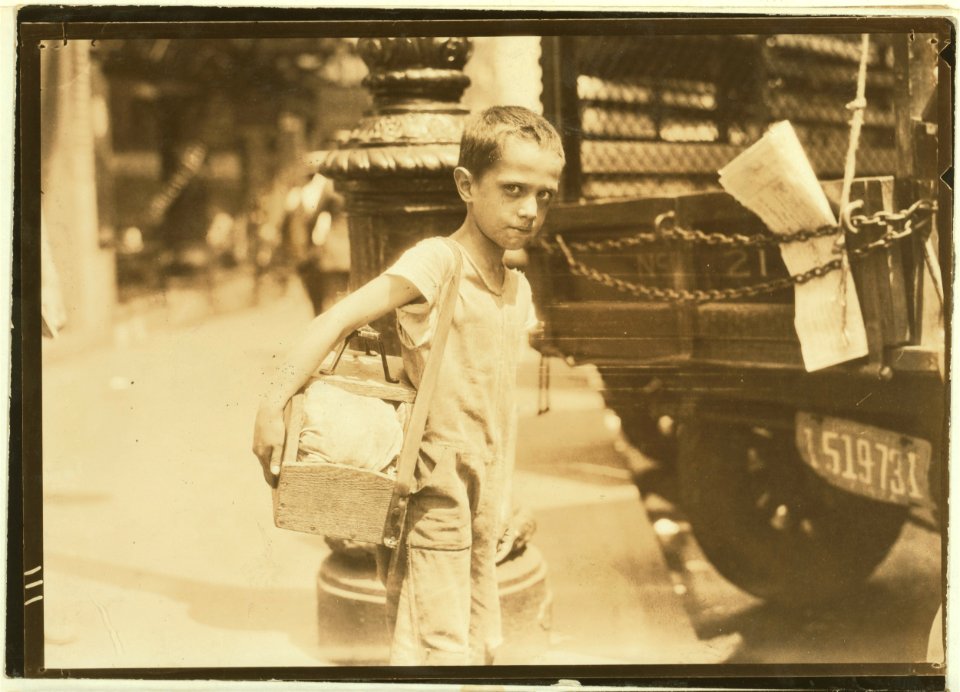 Tommie, very young shiner, Canal Street, New York City. Some of these youngsters do not know their ages nor how much they earn. July 25, 1924. LOC nclc.04047