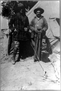 Tracy Mathewson and William Fox, news photographers, in camp with movie camera LCCN2003655589