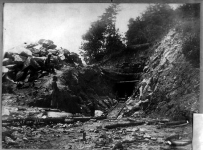 Track leading into tunnel in rock, with five men LCCN2002717779