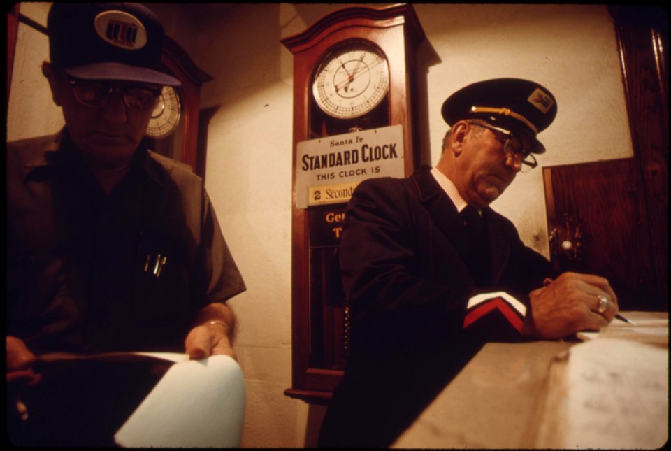 Train-engineer-left-and-conductor-check-in-at-the-dodge-city-kansas-station-prior-to-boarding-amtraks-southwest-limited-which-runs-between-los-angeles-california-and-chicago-june-1974 7158221428 o