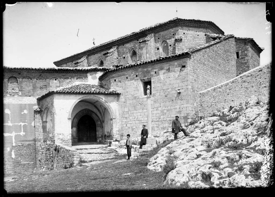 Tres homes davant l'atri i la porta de l'església del castell d'Alquézar
