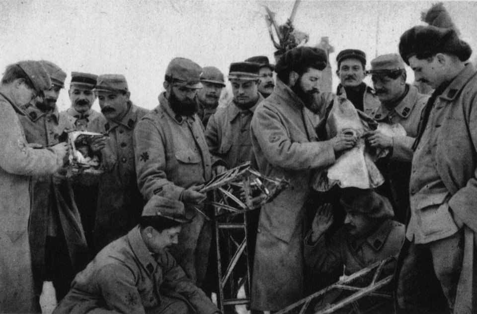 Truppen betrachten Ueberreste eines abgeschossenen Zeppelinluftschiffes