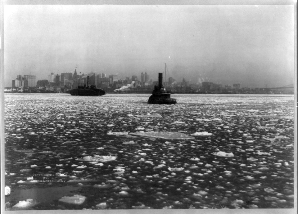 Tugboats and ferry on icy river, with New York City in backgrd. LCCN2002708829