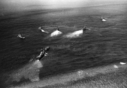 Tugs pull USS Frank Knox (DDR-742) from Pratas Reef, South China Sea, on 24 August 1965 (NH 74179)