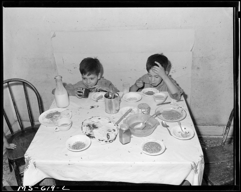 Two children of Joe L. Montoya, miner, eating in kitchen of their home in company housing project. Royal Coal... - NARA - 540532