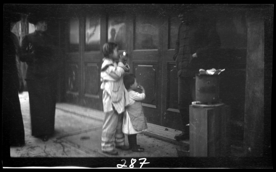 Two children standing on a sidewalk eating, Chinatown, San Francisco LOC agc.7a09045