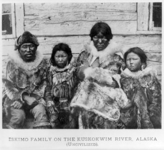 Two Eskimo families in front of houses on the Kuskokwim River, Alaska- uncivilized family in native dress LCCN2007675424