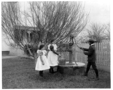 Two girls and a boy pumping water at well of Hampton Institute graduate LCCN2001703865