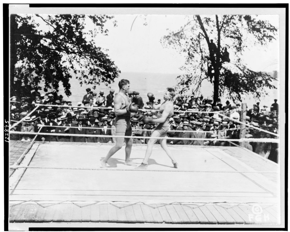 Two boxers in outdoor boxing ring, surrounded by audience LCCN99402331