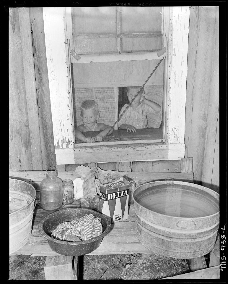 Two children looking out of window in home of William McMillan, miner, living in this company housing project.... - NARA - 540614