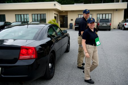 Two law enforcement explorers walking away from a car