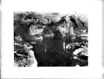 Two men at an outlet of Montezuma's Well, south side, near Camp Verde, Arizona, ca.1900 (CHS-4235)