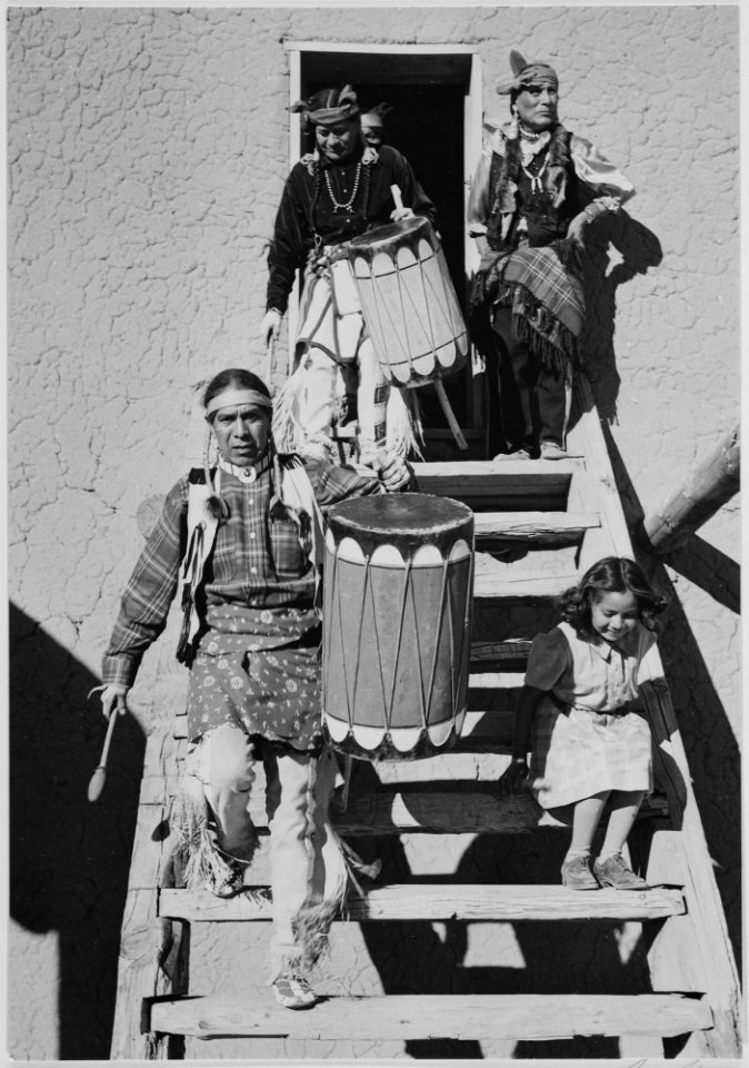 Two Indians descending wooden stairs, carrying drums, another Indian and child near by, Dance, San Ildefonso Pueblo, Ne - NARA - 519978