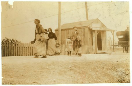 Two of the young oyster shuckers and baby-tenders going home at 5-00 P.M. after a day begun at 4-00 A.M. and spent shucking oysters and tending baby. Smallest one is 'Teeny.' Other is LOC nclc.00874