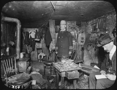 Two officials of the New York City Tenement House Department inspect a cluttered basement living room, ca. 1900 - NARA - 535469