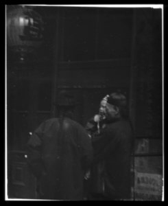 Two men, one holding a child, standing in the street, Chinatown, San Francisco LOC agc.7a55019