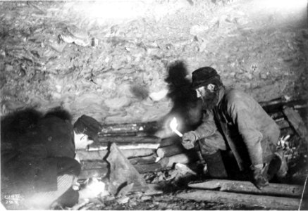 Two men, identified as Gorst and Ainsworth, building a fire in a mine shaft to thaw the frozen ground, Yukon Territory, ca 1898 (CURTIS 1829)