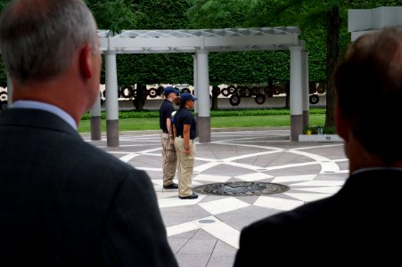 Two men watch as law enforcement explorers stand at attention at the National Law Enforcement Officers Memorial photo