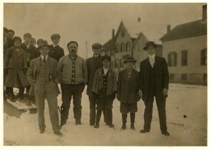 Two mill boys (small boys between the men) Jo Viera, Antone Mello. Loafing around the beach near the mill Sunday P.M. with some school boys. Compare the ages of the school boys (12 and 13 LOC nclc.02480