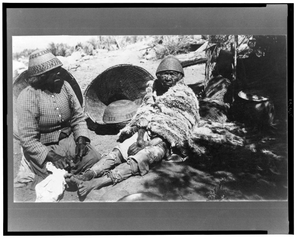 Two old Paiute Indian women with baskets and woven hats, one identified as Teha LCCN2002713058
