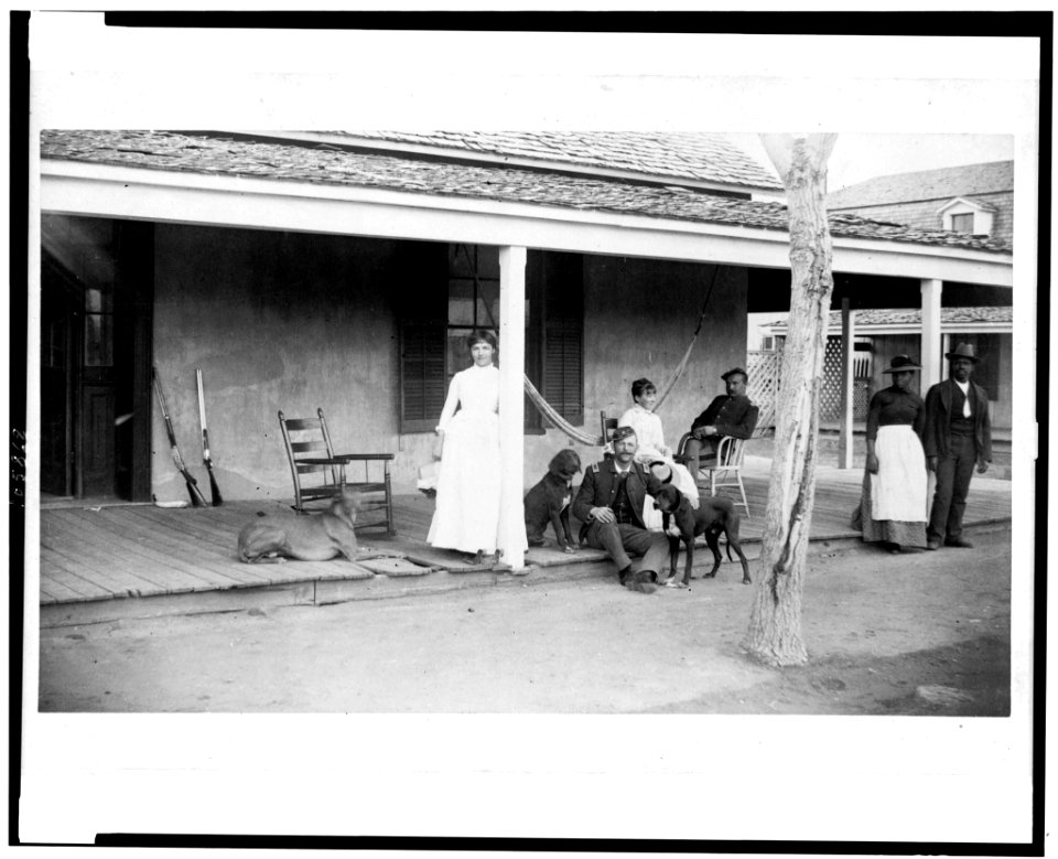 Two soldiers and two women on porch, with Afro-American woman and man to right, Fort Verde, Arizona LCCN92513330