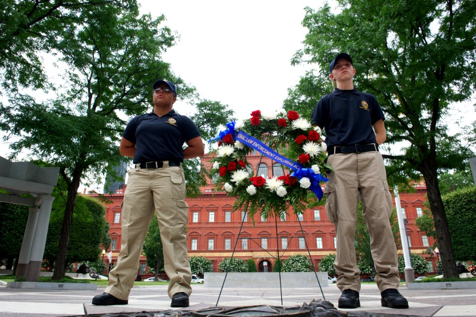 Two law enforcement explorers stand next to a wreath at the National Law Enforcement Officers Memorial