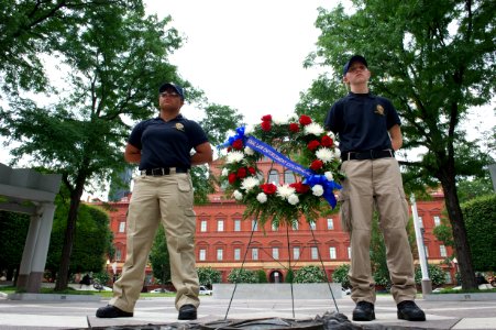Two law enforcement explorers stand next to a wreath at the National Law Enforcement Officers Memorial photo