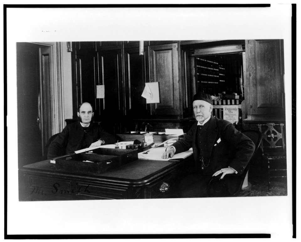 Two Treasury Department employees seated at desk in office LCCN00649577
