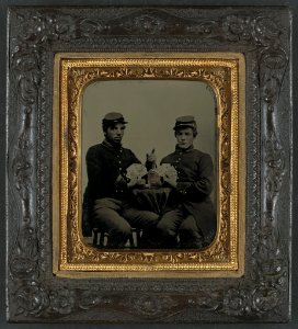 Two unidentified soldiers in Union uniforms drinking whiskey and playing cards, c1863