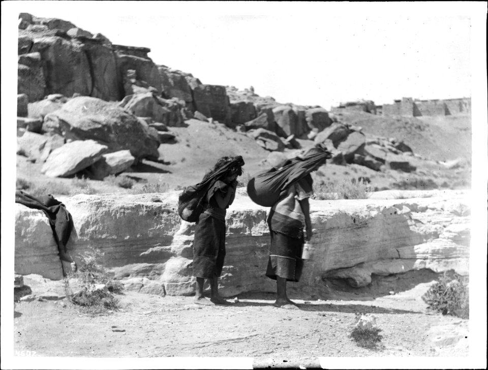 Two women carrying water from the valley to the pueblo of Mishongnovi (Mashongnavi) atop Second Mesa, Arizona, ca.1898 (CHS-4607)