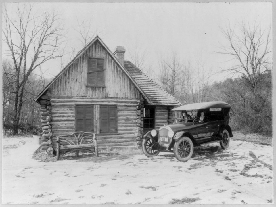 Two women in new Oldsmobile in front of log cabin, Rock Creek Park, Washington, D.C.; picture made for Oldsmobile Sales Co. LCCN2001706378