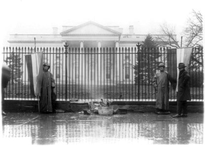 Two suffragettes and bonfire at front gate, White House, Washington, D.C. LCCN2001706175 photo