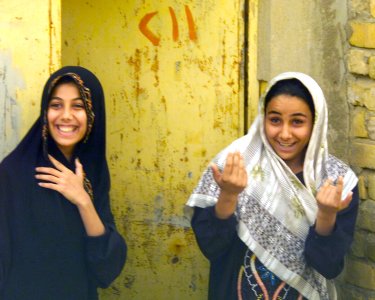 Two young local women communicate with US Marine Corps (USMC) cameraman Sergeant Mauricio Campino, USMC, at Al Hay, Iraq, DM-SD-04-07564
